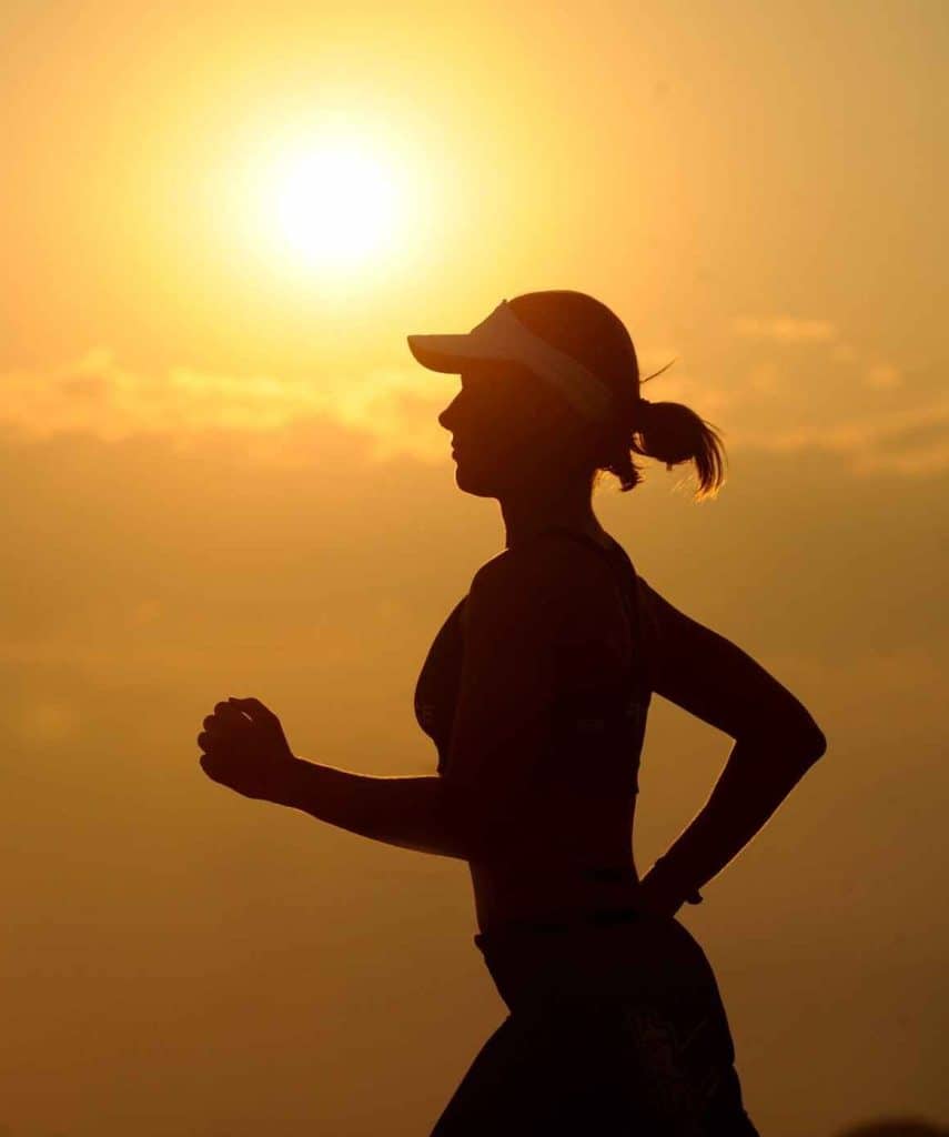 A woman jogging at sunset.