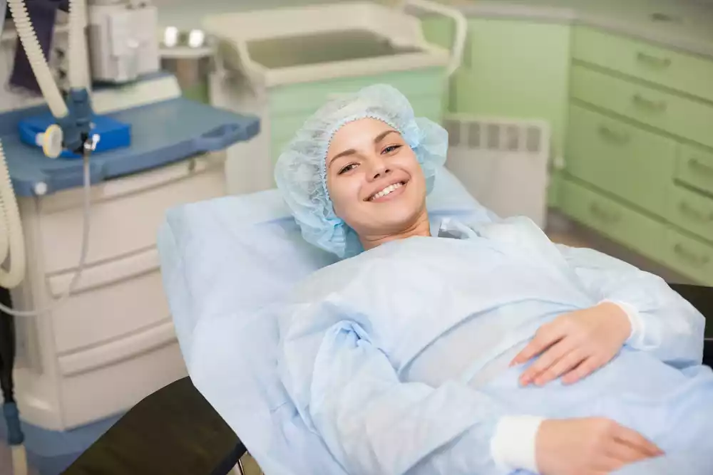 A woman is recovering in a hospital bed.