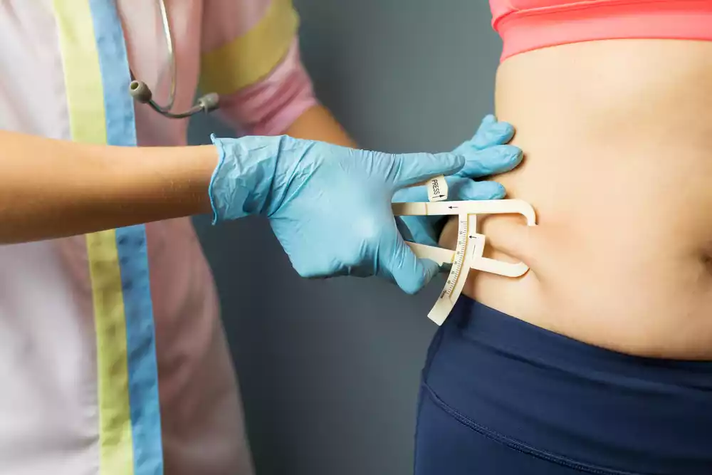 A woman's stomach being measured by a doctor.
