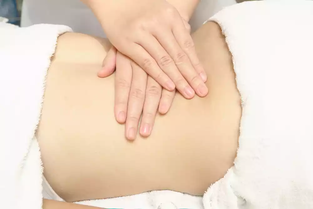 A person lying down receiving a back massage.