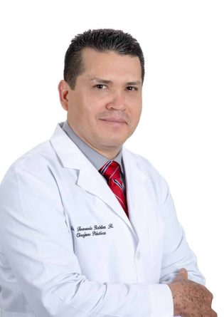 A man in a white lab coat posing for a plastic surgery photo.
