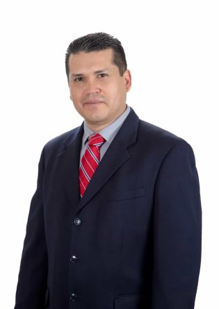 A man in a suit and tie posing for a photo in Tijuana.
